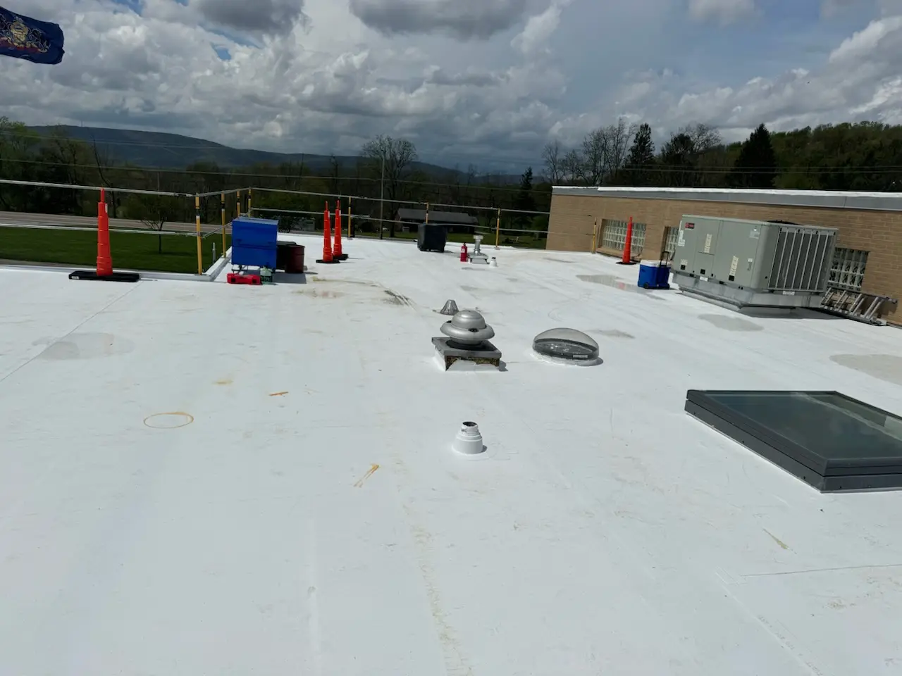 Newly installed white TPO commercial roof with HVAC units and safety railings for the Pennsylvania Game Commission in Central PA.
