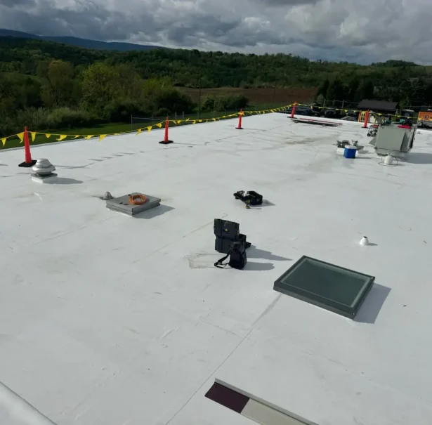 Completed TPO Roof Replacement – Central PA Completed TPO commercial roof replacement in Central Pennsylvania with skylight and rooftop equipment visible.