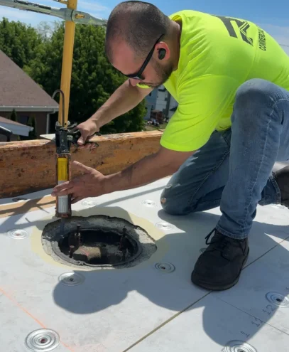 Joe from RTG Solutions sealing a roof drain penetration during the single ply roofing installation at Christ the King Church in Pennsylvania.