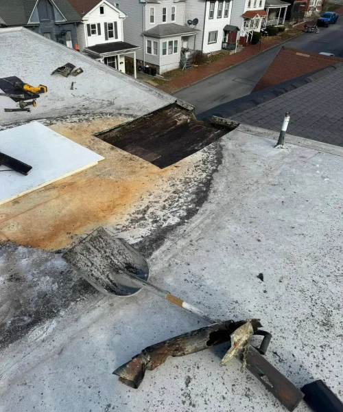 RTG Solutions team repairing commercial roof waterproofing in Lock Haven, addressing standing water issues caused by elevated drain height.