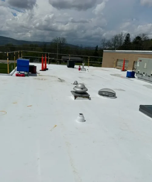 Newly installed white TPO commercial roof with HVAC units and safety railings for the Pennsylvania Game Commission in Central PA.