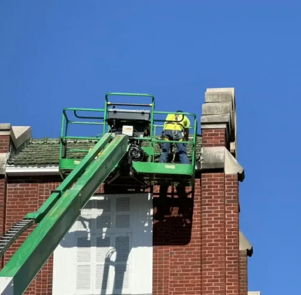 Historic roof restoration at historic Immaculate Conception Church Workers on lift restoring Ludowici terracotta tile roof on Immaculate Conception Church historic preservation project.
