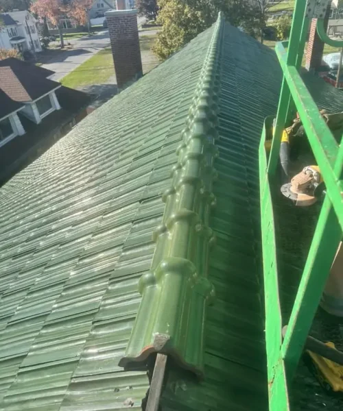 Restored Ludowici green terracotta tile roof ridge at Immaculate Conception Church historical preservation project.