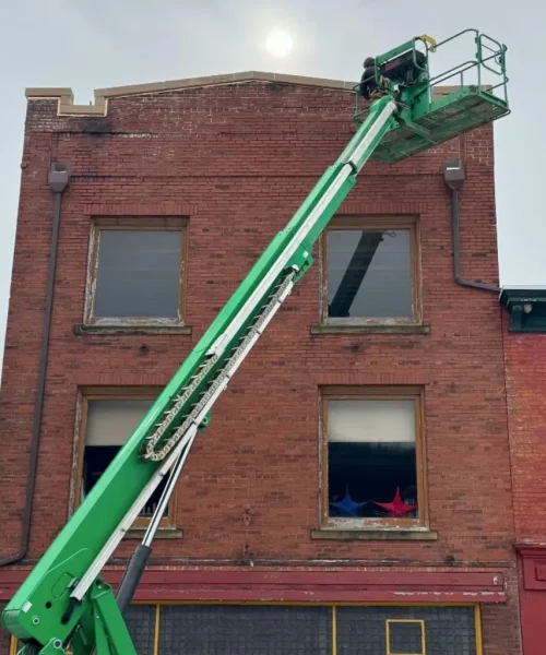 Boom lift access for brick parapet coping stone repairs at the Maxwell Building in Renovo, PA