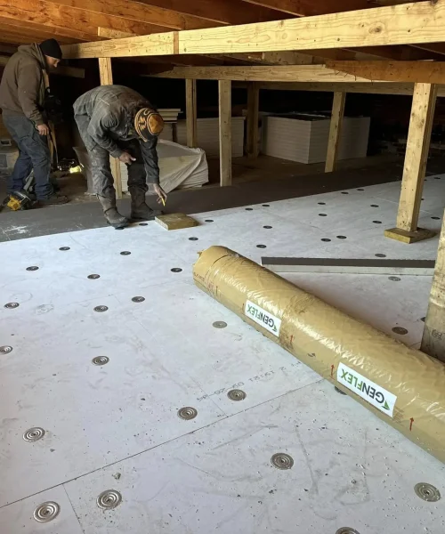 Crew fastening insulation boards during commercial roof restoration at the Maxwell Building.