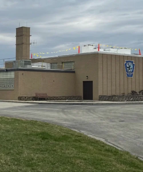 Exterior of the PA Game Commission facility in Bolivar, PA during a low-slope commercial roof replacement with new white TPO membrane installation underway.