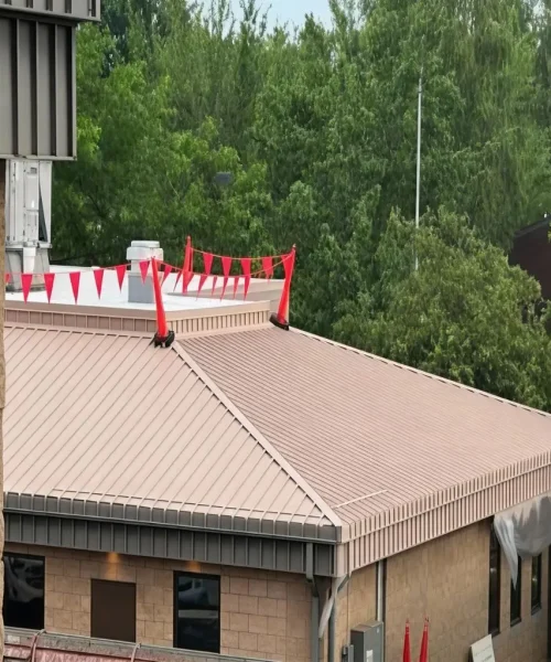 Commercial building with tan metal roof undergoing acrylic coating project.