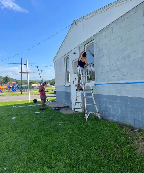 Early renovation of RTG Solutions’ commercial roofing office in Lock Haven, PA, with Sarah leading painting work.