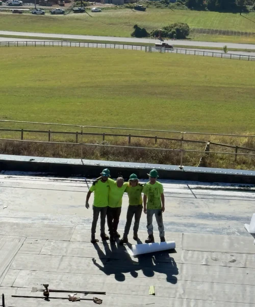 Four RTG Solutions roofers standing together on an EPDM commercial roof during a replacement project at Shippensburg University in Shippensburg, Pennsylvania.