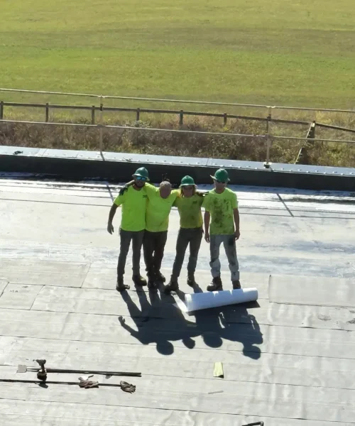 Four RTG Solutions roofers standing together on an EPDM commercial roof during a replacement project at Shippensburg University in Shippensburg, Pennsylvania.