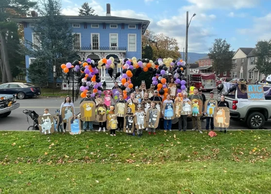 RTG Solutions team at the Lock Haven Halloween Parade with decorated float, balloons, and community members.