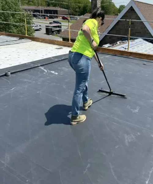 Sarah Getz, president of RTG Solutions, brushing EPDM surface during church reroof project in Houtzdale.