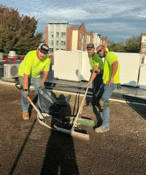 RTG Solutions roofing crew cleaning gravel from a flat roof during a Shippensburg University re-roof