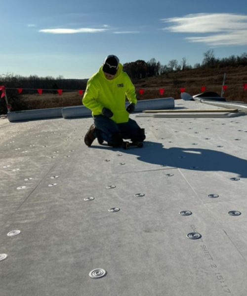 RTG Solutions team member preparing roof anchorage points on a flat roof as part of safety installation work in Central Pennsylvania