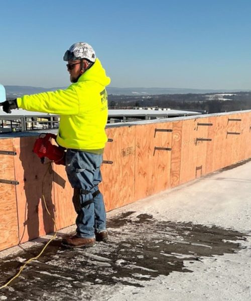 RTG Solutions worker installing roof edge protection near a parapet during safety installation work across Central Pennsylvania